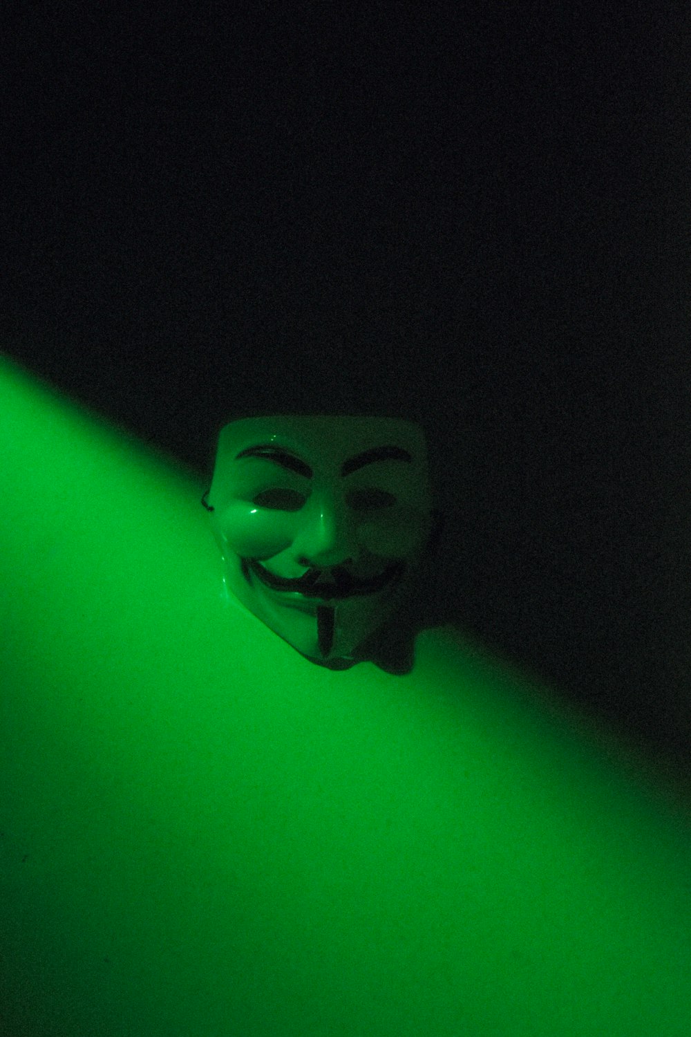a mask with a green light behind it