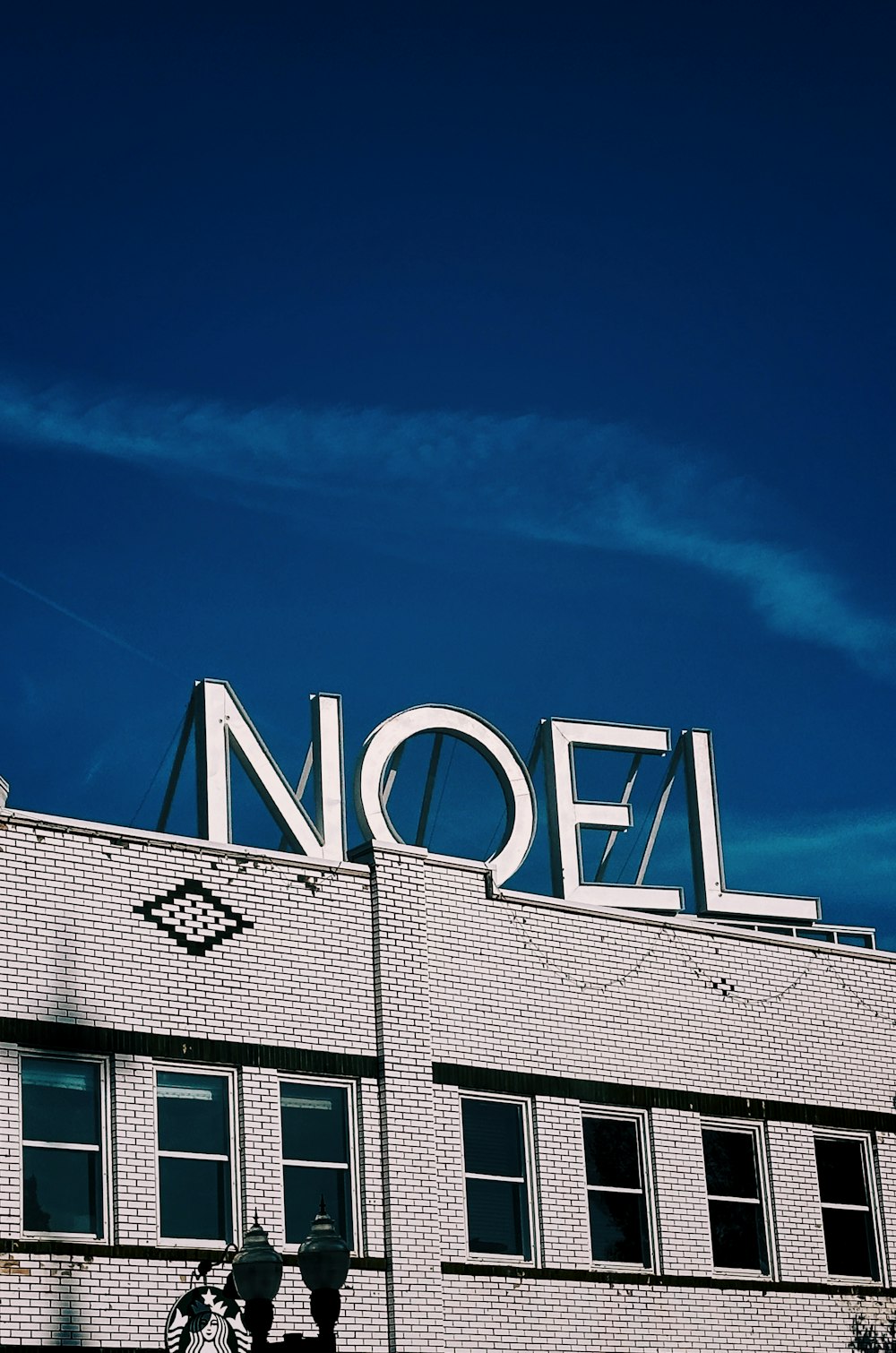 a white brick building with a neon sign on top of it