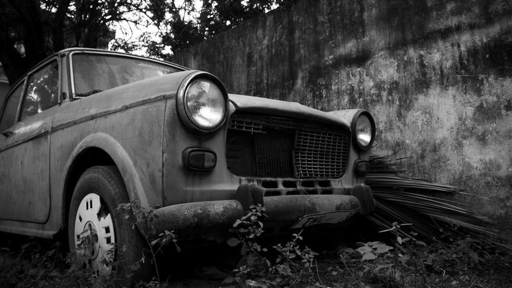 an old car is parked in the grass
