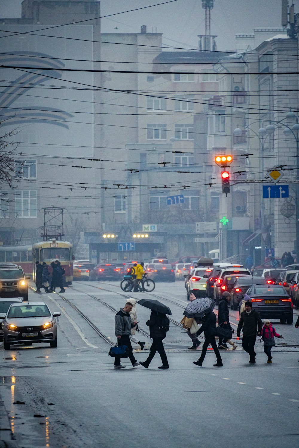 a group of people walking across a street holding umbrellas