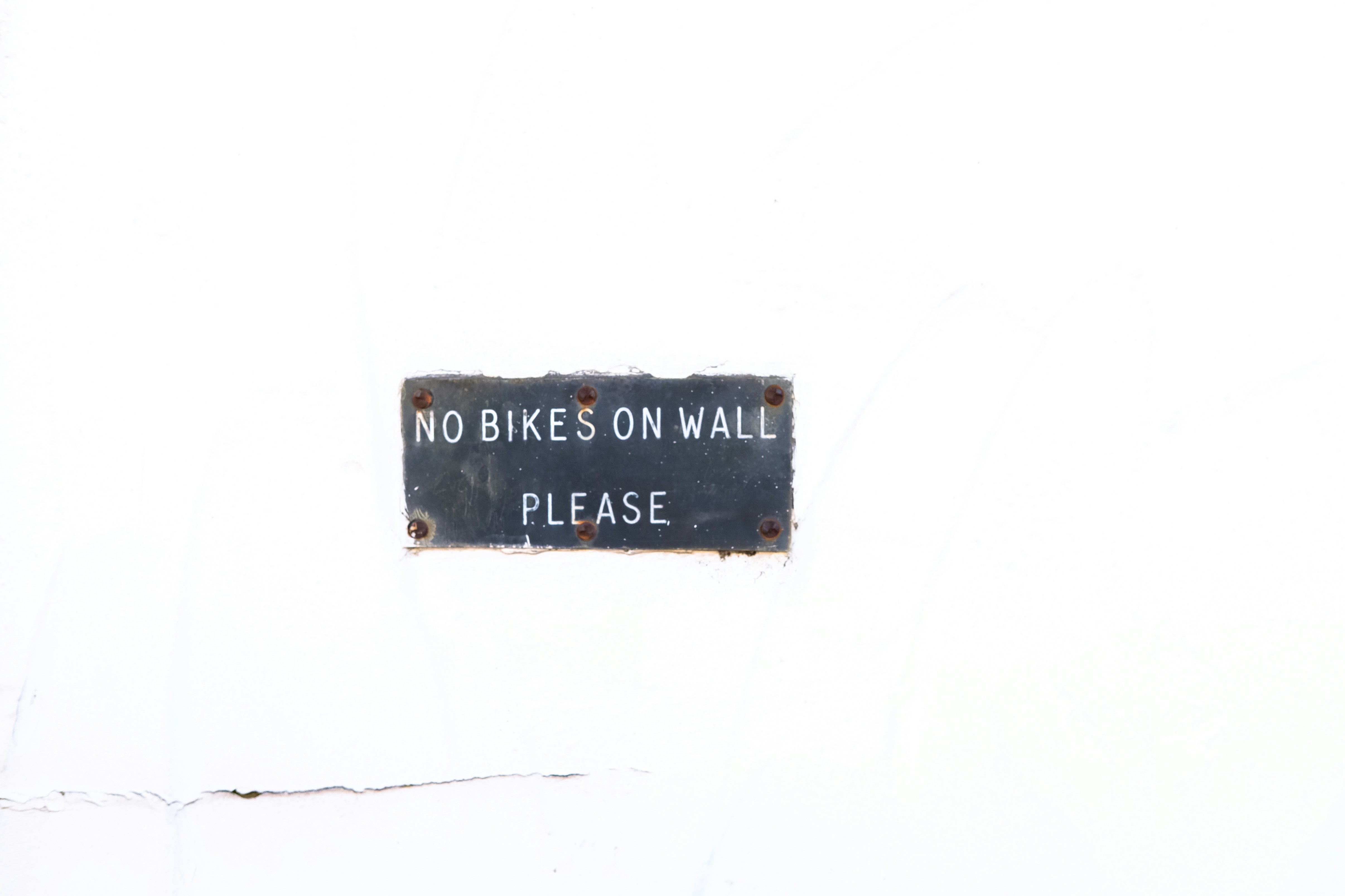 uma placa em uma parede que diz não há bicicletas na parede, por favor