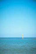 Ocean monitoring buoy transmitting data under a clear blue sky.
