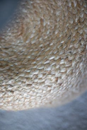 Close-up view of a woven texture made of natural fibers, displaying a tightly interlaced pattern with a soft focus on the edges.