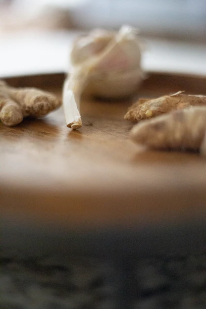 Close-up of vibrant dried ginger and garlic cloves arranged on rustic wooden surface