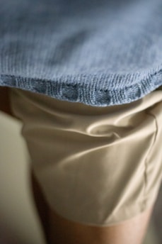 A close-up of elegant trousers folded neatly on a table.