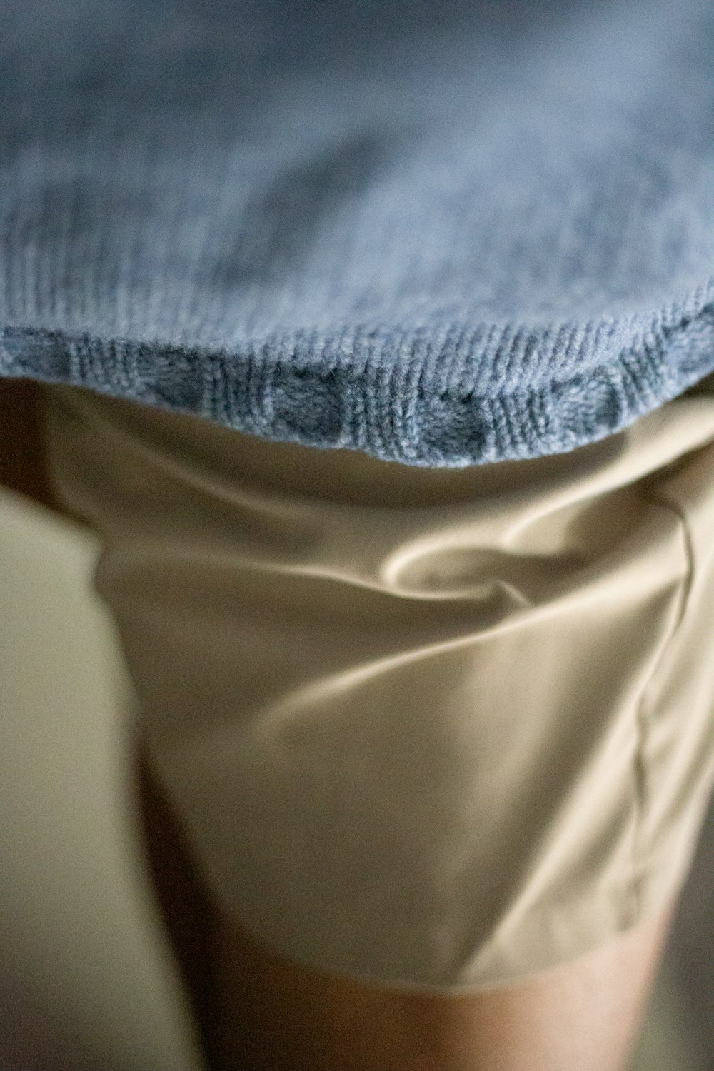 a close up of a person's legs with a blue blanket on top of