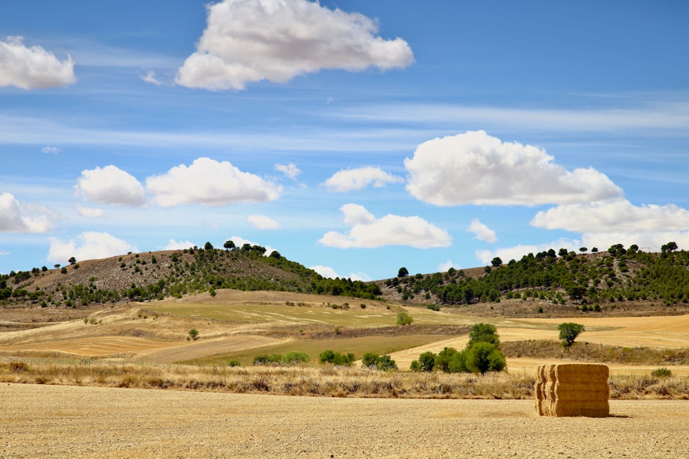 a field with a hay bail in the middle of it