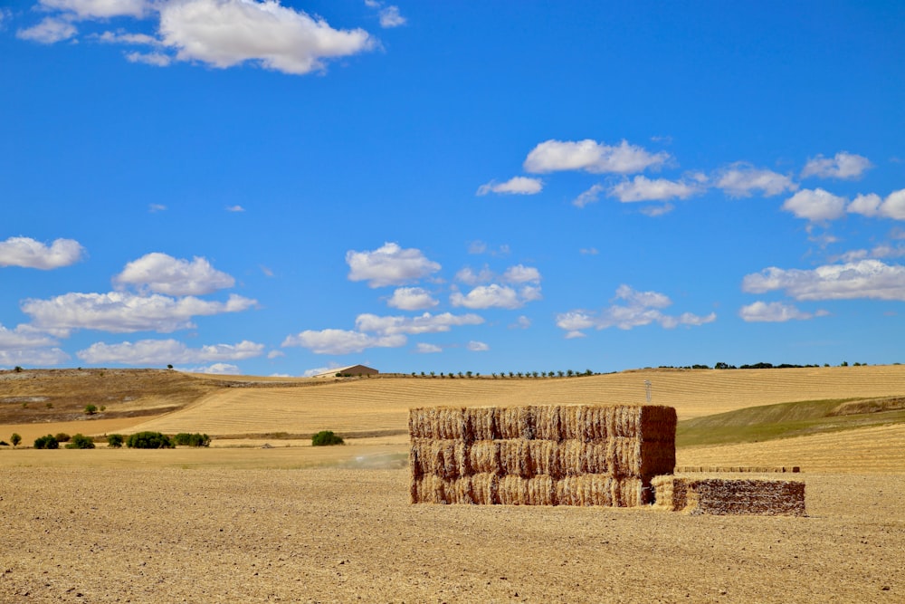 a large stack of hay sitting in the middle of a field