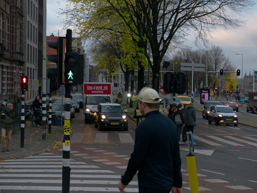 信号機の横の通りを歩いて渡る男性