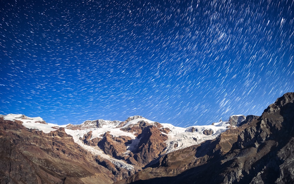a mountain range with a star trail in the sky