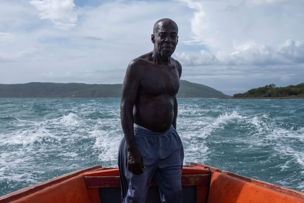 a man standing on the front of a boat in the ocean