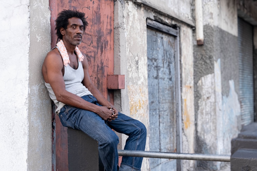 a man sitting on a ledge of a building