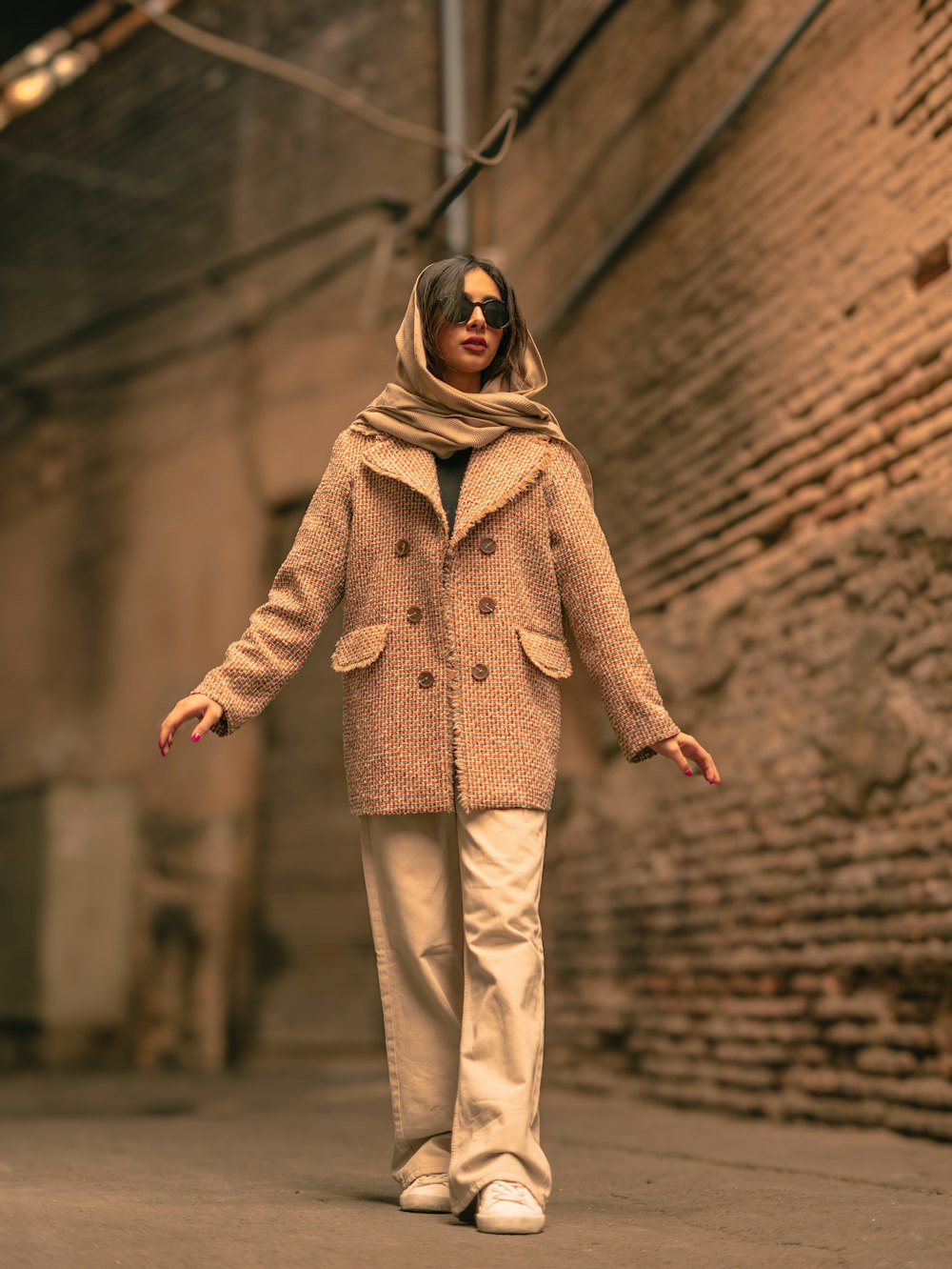 a woman walking down a street in a coat