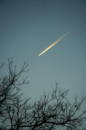 Darkstar L39 Albatros soaring against a twilight sky with trails of exhaust.