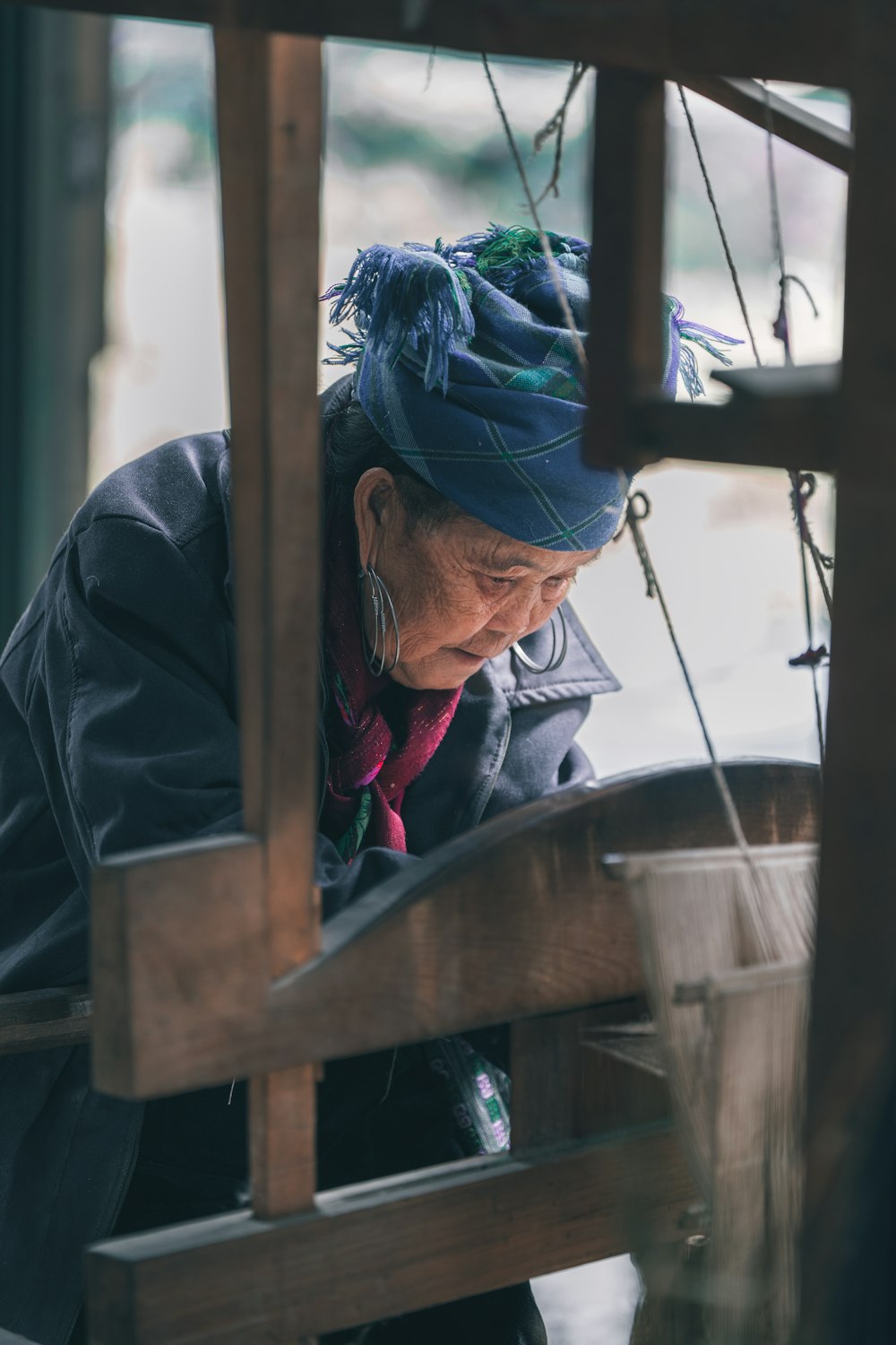 Eine alte Frau arbeitet an einem Stück Holz