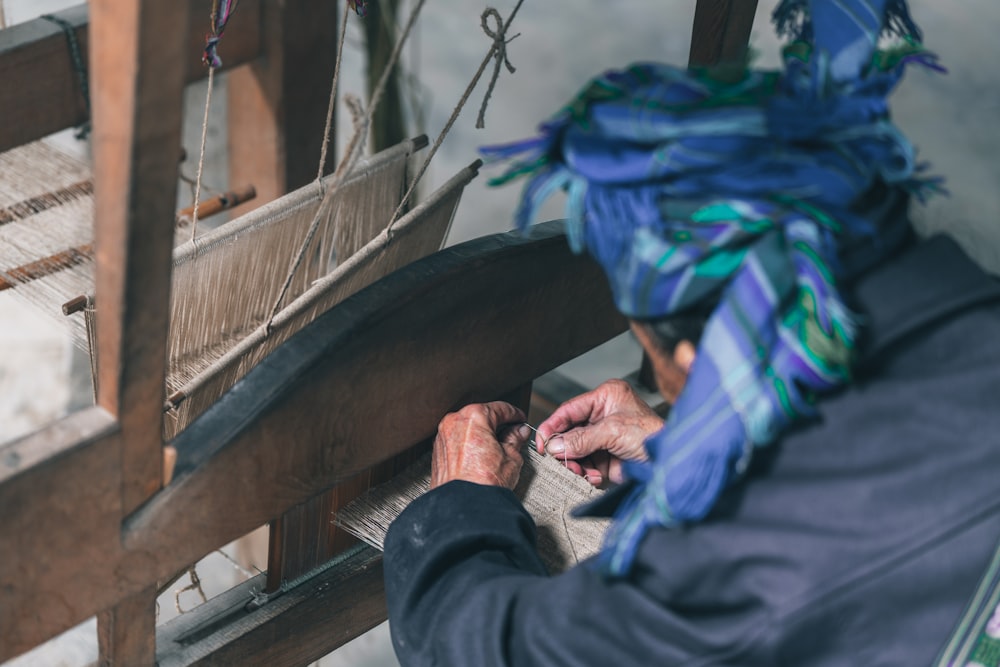 a woman is weaving fabric on a loom