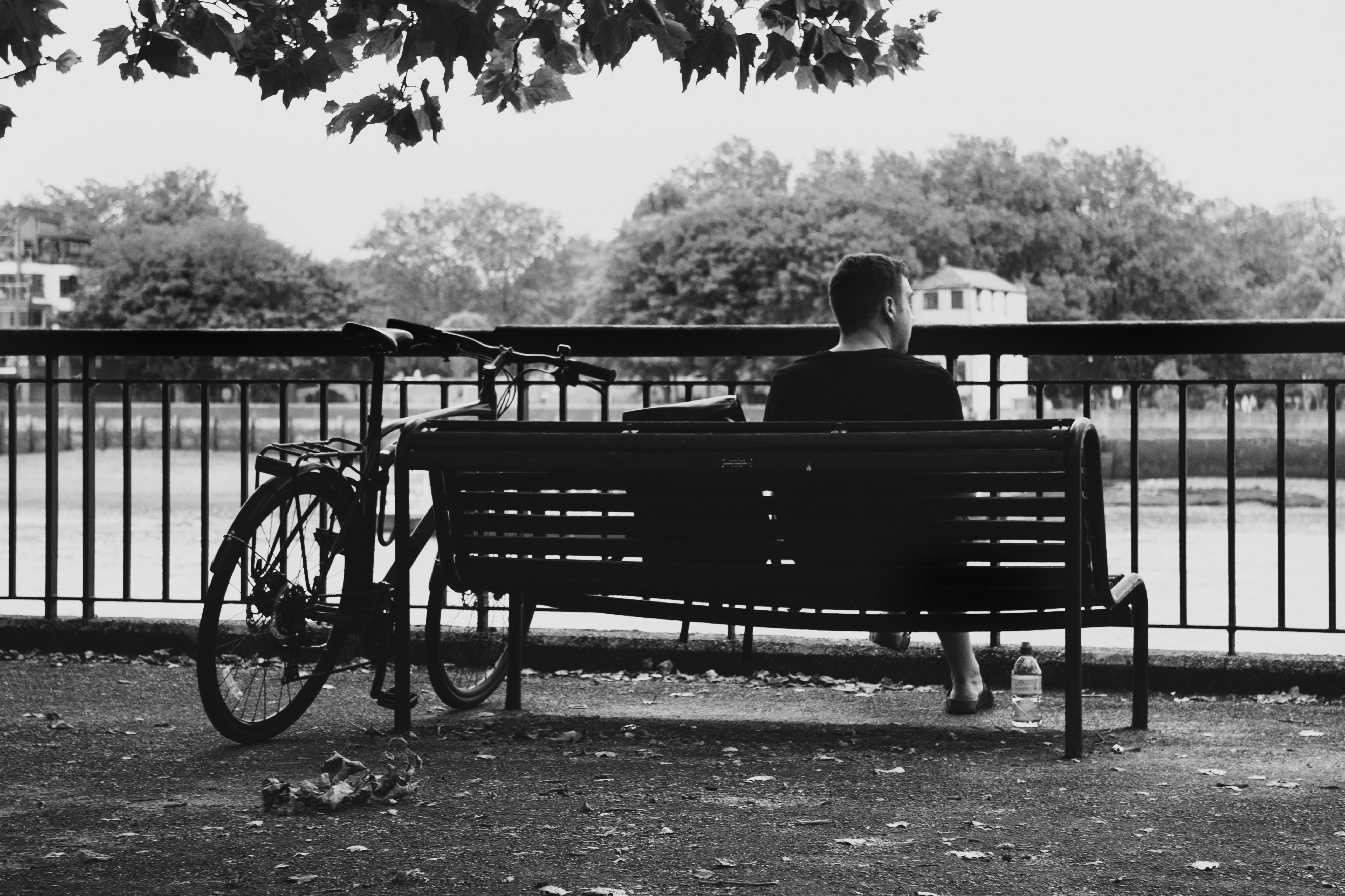 a man sitting on a bench next to a bike