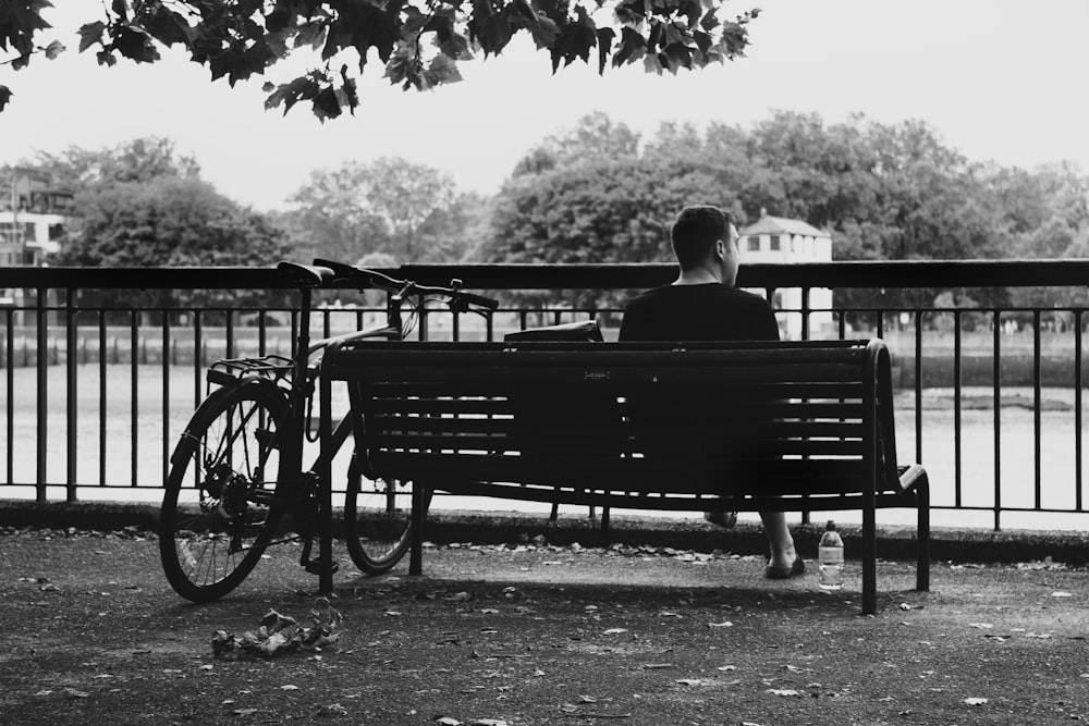 a man sitting on a bench next to a bike