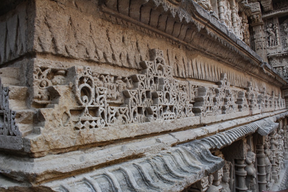 a close up of a stone wall with carvings on it