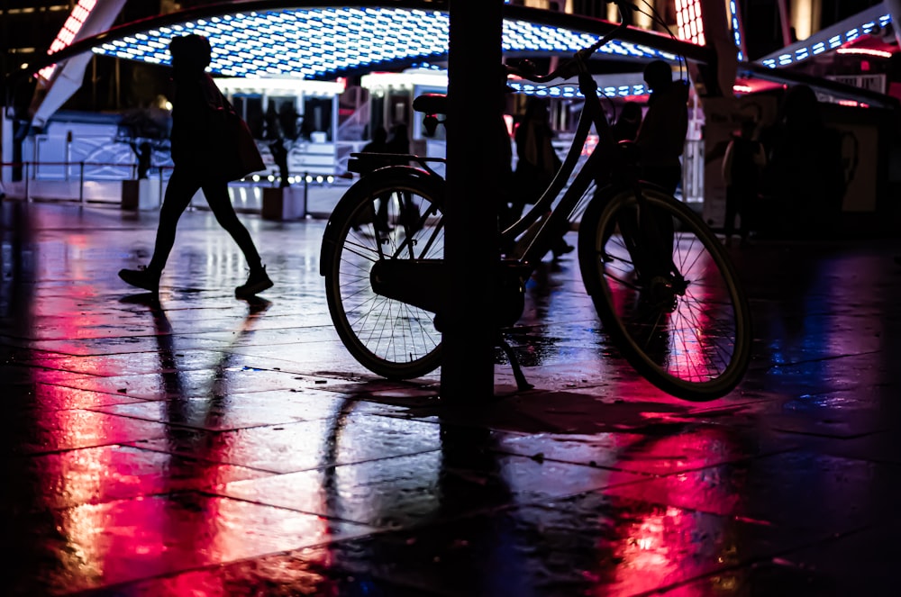 a couple of people walking down a street next to a bike