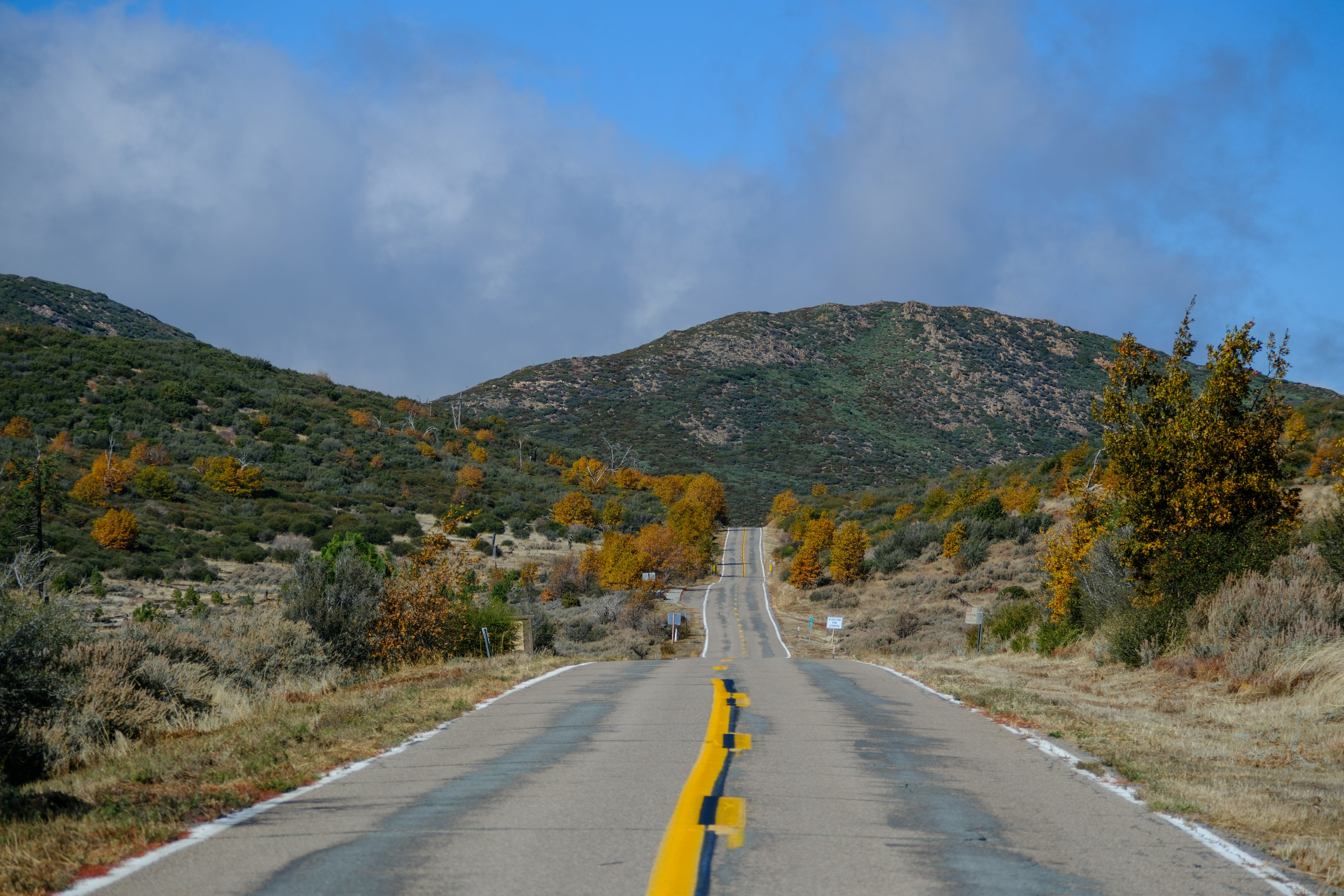 an empty road with a mountain in the background