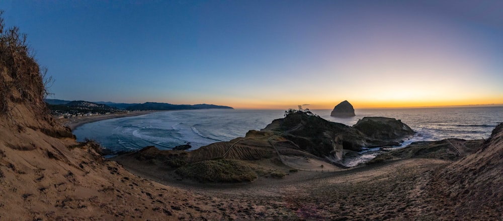 the sun is setting over a rocky beach