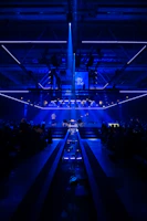 Guests enjoying a showcase performance on stage, bathed in dramatic black and gold lighting.