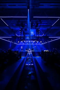 An elegant stage setup with a magician mid-performance, surrounded by a deep blue and red ambiance.