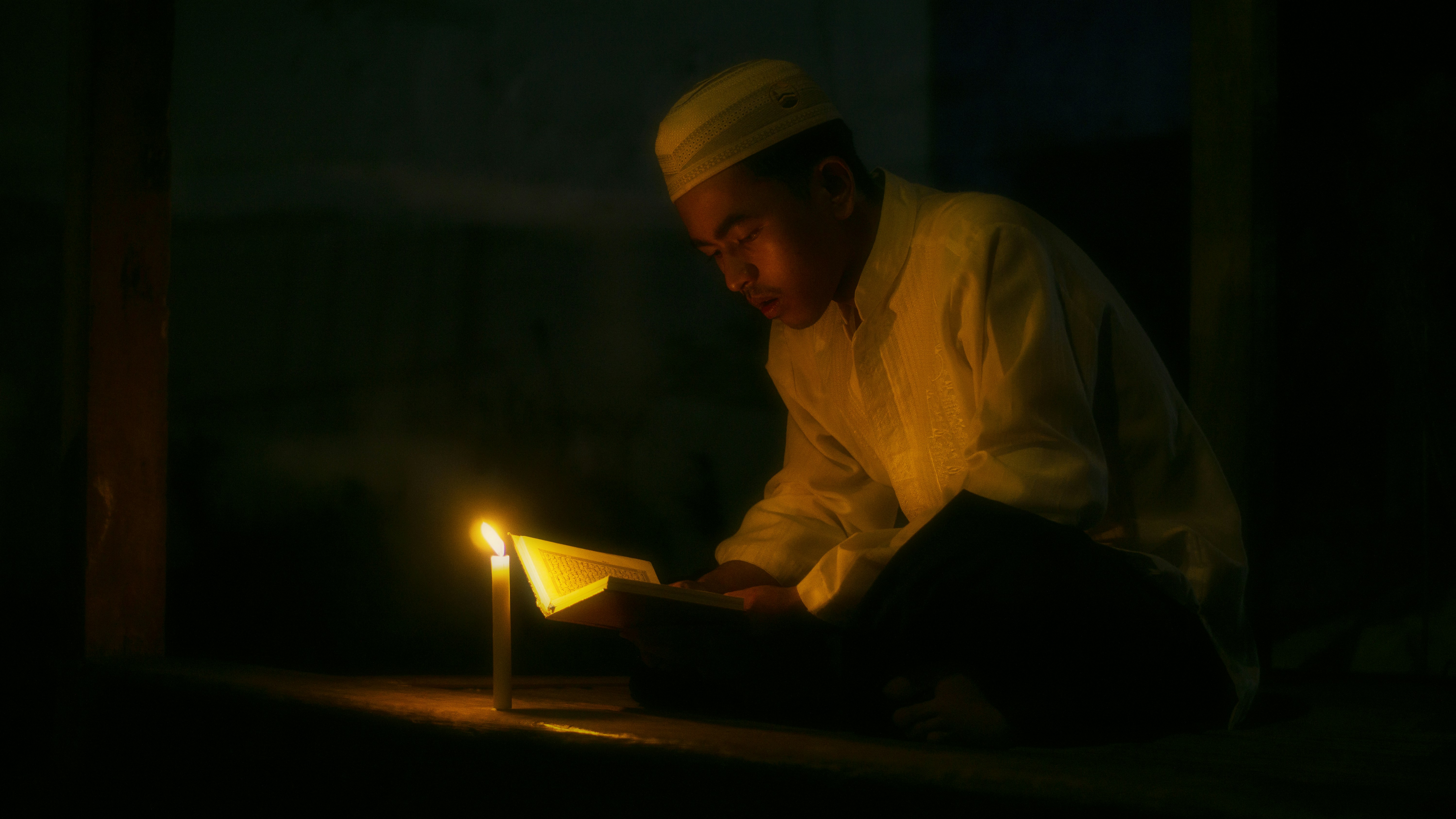 a man reading a book in the dark