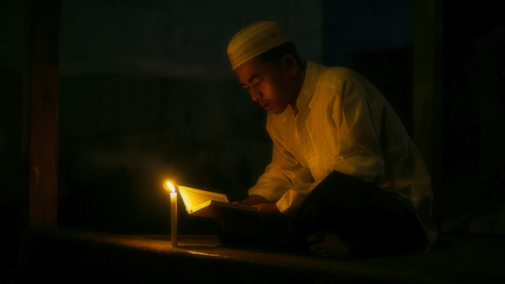 a man reading a book in the dark