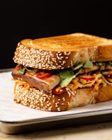 a sandwich on a plate with sesame seeds