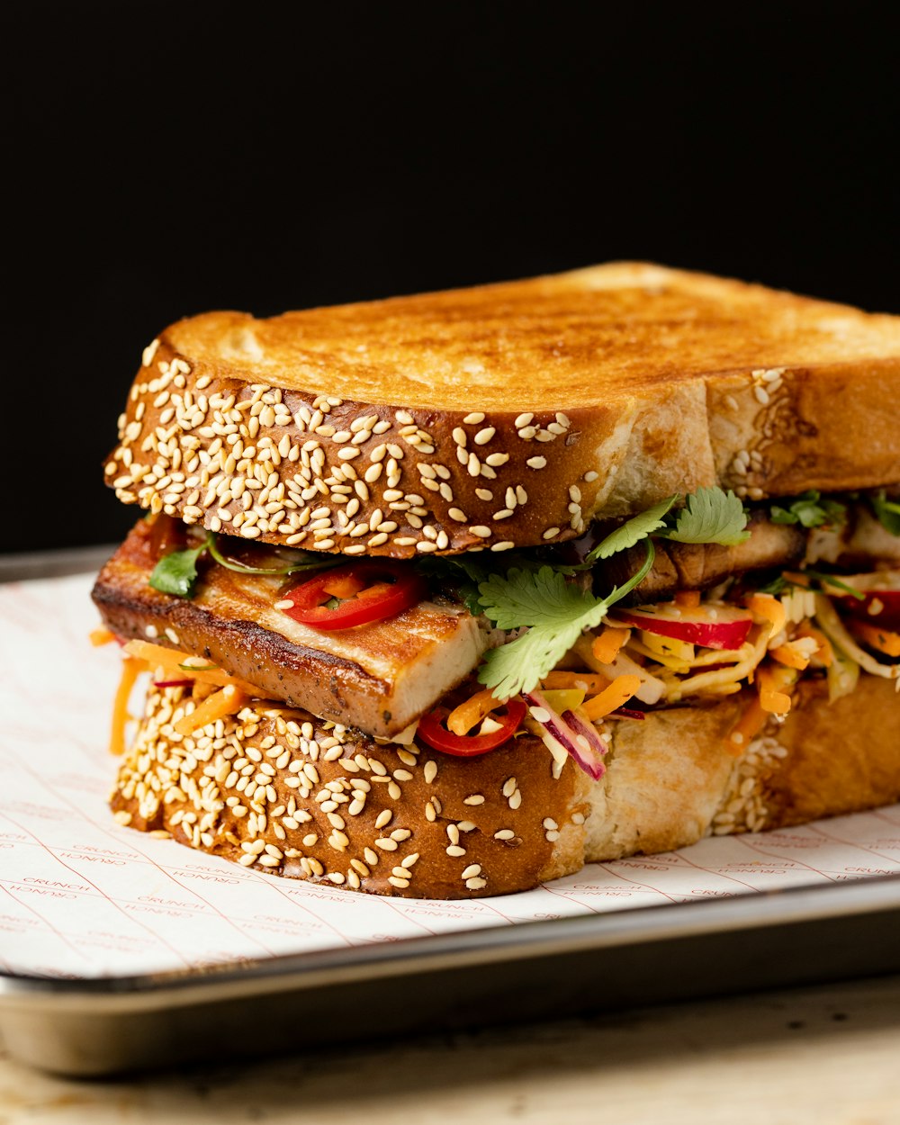 a sandwich on a plate with sesame seeds