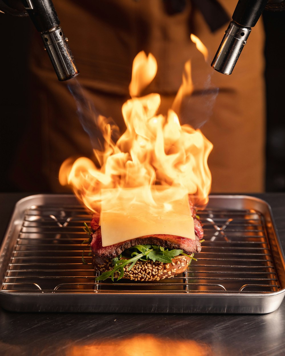 a sandwich on a grill with flames coming out of it