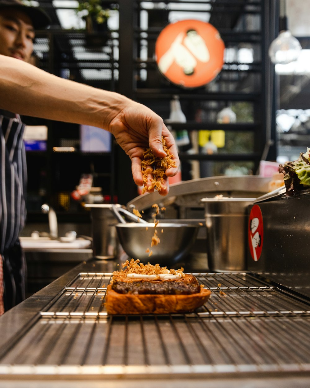 a person putting food on top of a piece of bread