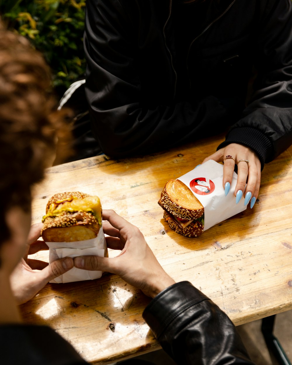 a person sitting at a table with a sandwich