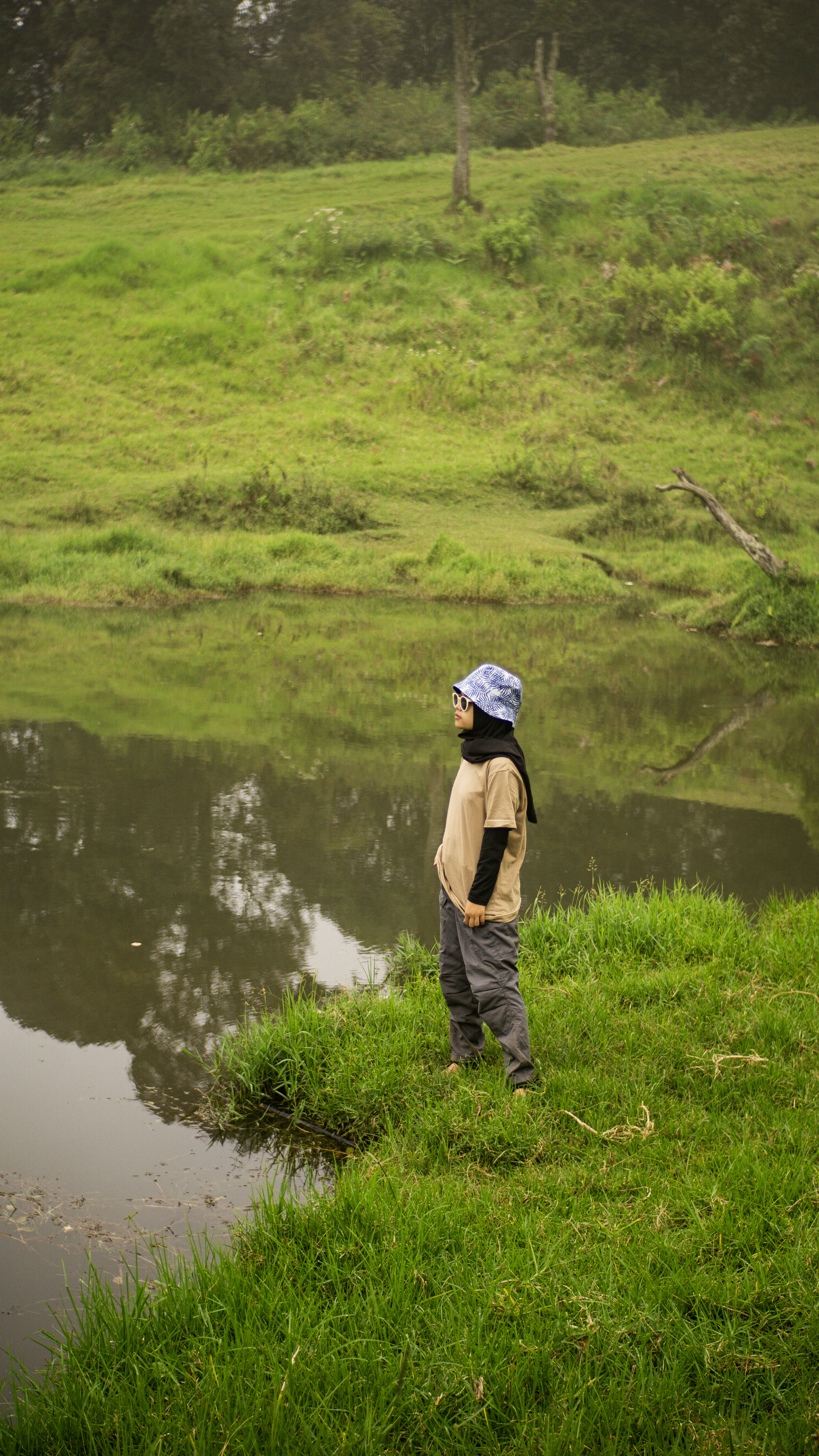 a young boy standing on top of a lush green field