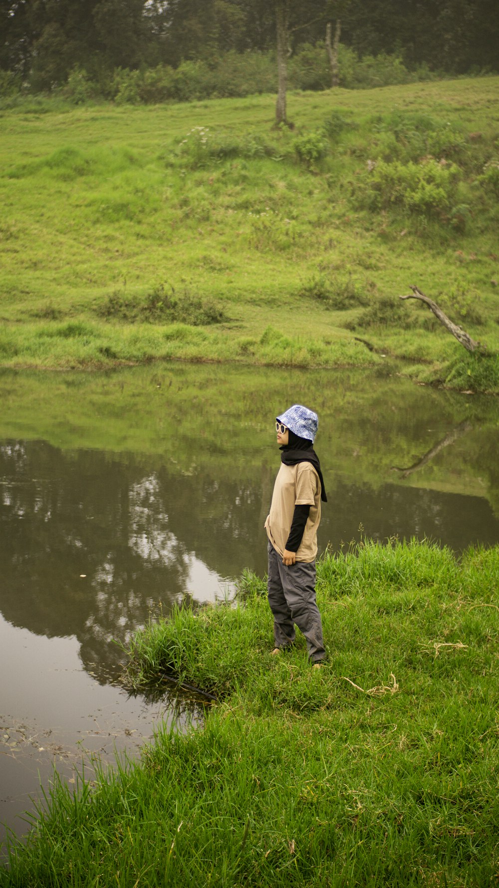 a young boy standing on top of a lush green field