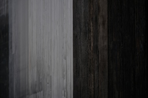 Close-up of customized natural wood and slate gray panels blending with forest green surroundings.