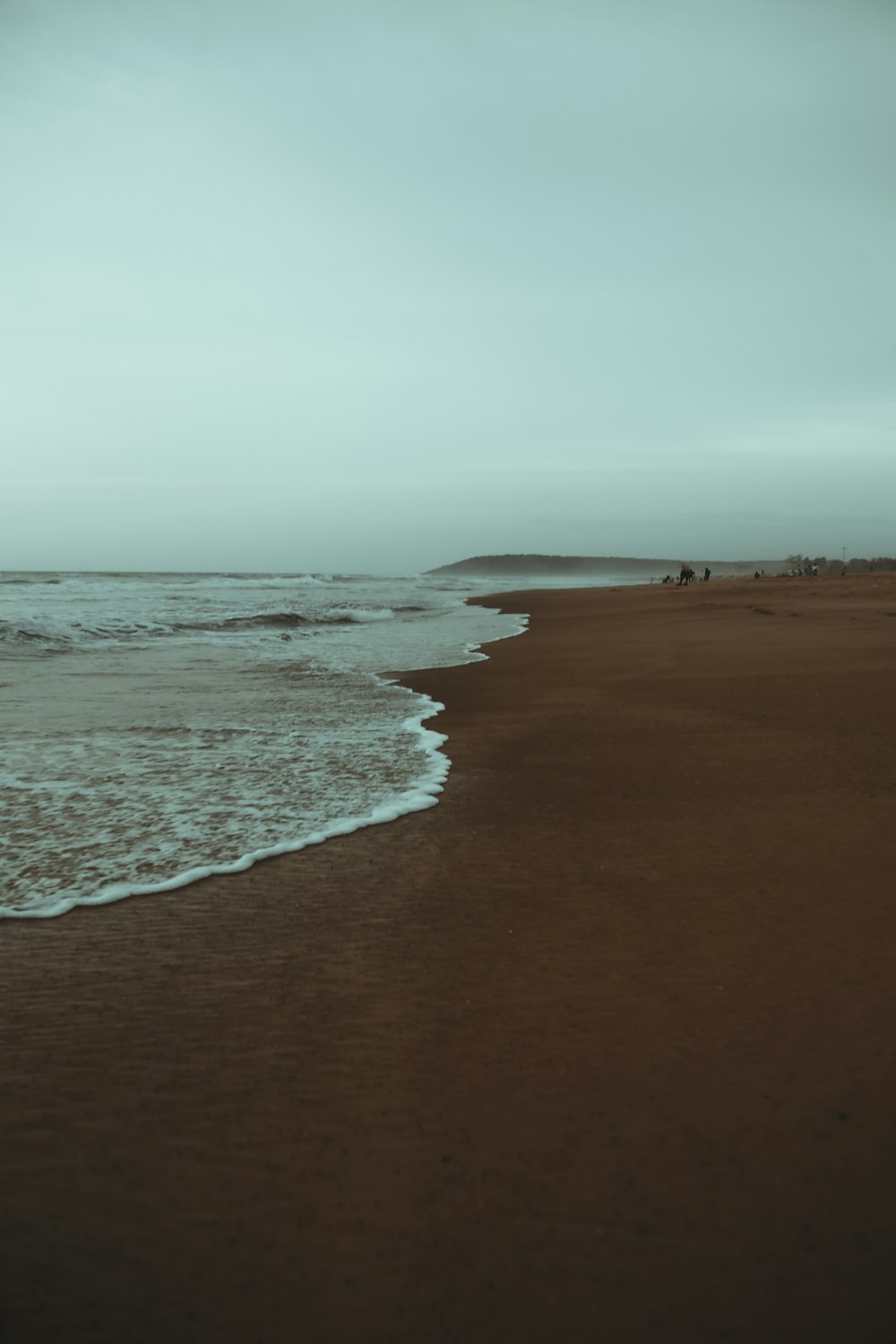 a sandy beach with waves coming in to shore