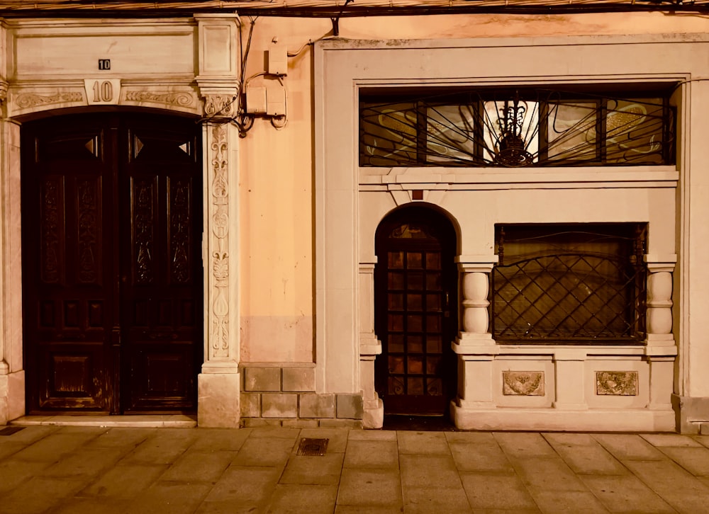 a building with two doors and a clock on the front of it