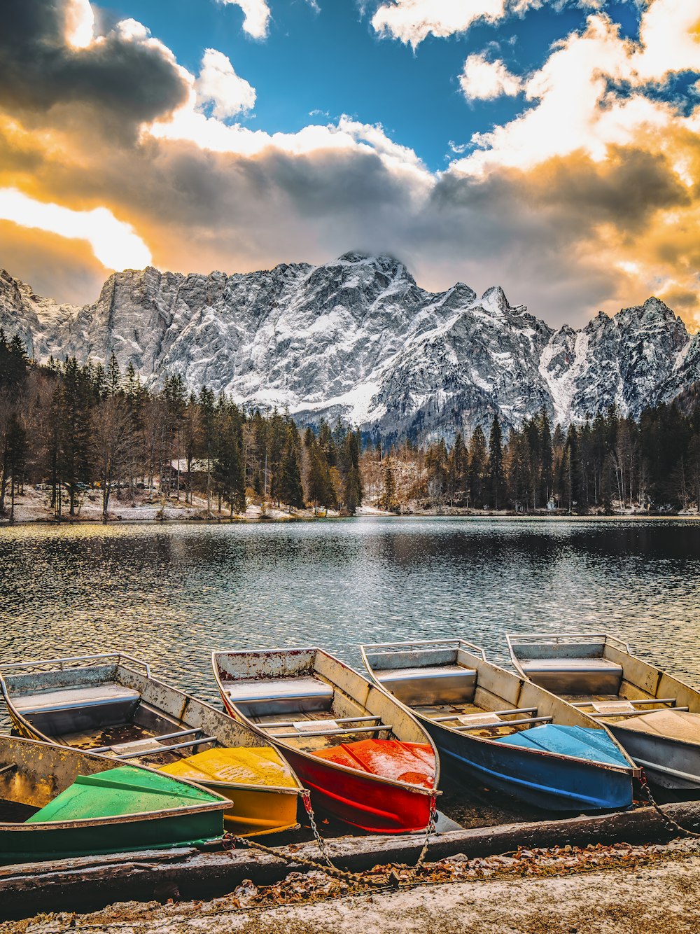 a row of boats sitting on top of a lake
