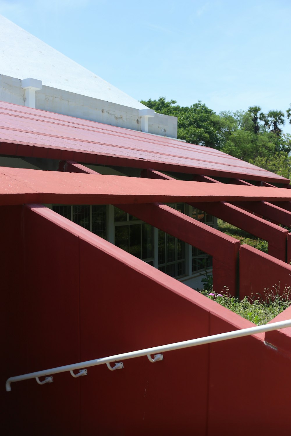 a red building with a white roof and a metal railing