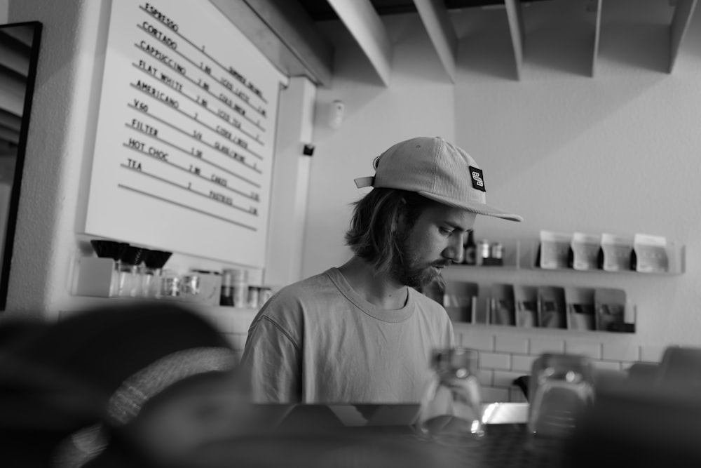 a man sitting at a counter with a hat on