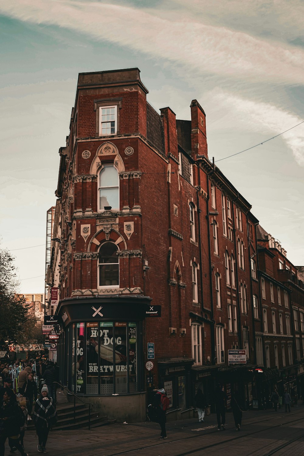 a tall red brick building sitting on the side of a street