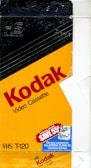 A vintage Kodak video cassette packaging with a predominantly yellow and black design. The prominent red text spells 'Kodak Video Cassette', while the bottom left corner displays 'VHS T-120'. There is a blue promotional label offering a discount on Kodak Fling 35 Camera Series, valid until 1991.
