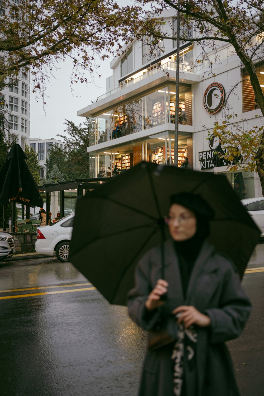 a woman walking down a street holding an umbrella