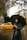 Man standing on a rainy street corner wearing a sleek Nimbusvale raincoat with an umbrella