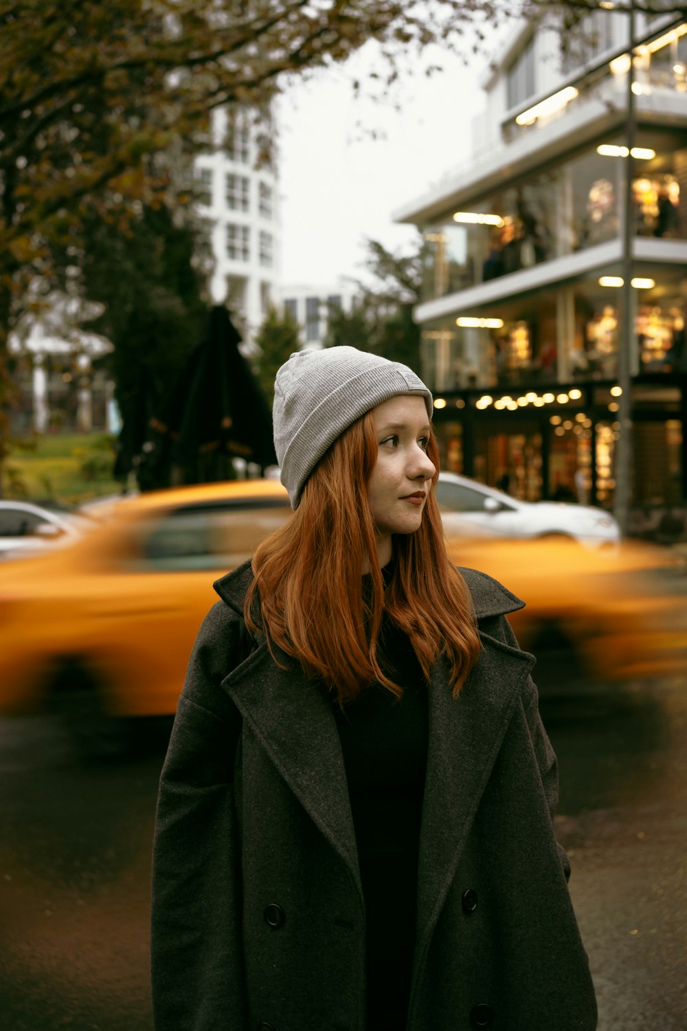 a woman standing in front of a yellow taxi