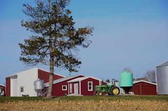 A farmer inspecting an agricultural propane tank on a sunny rural farm.