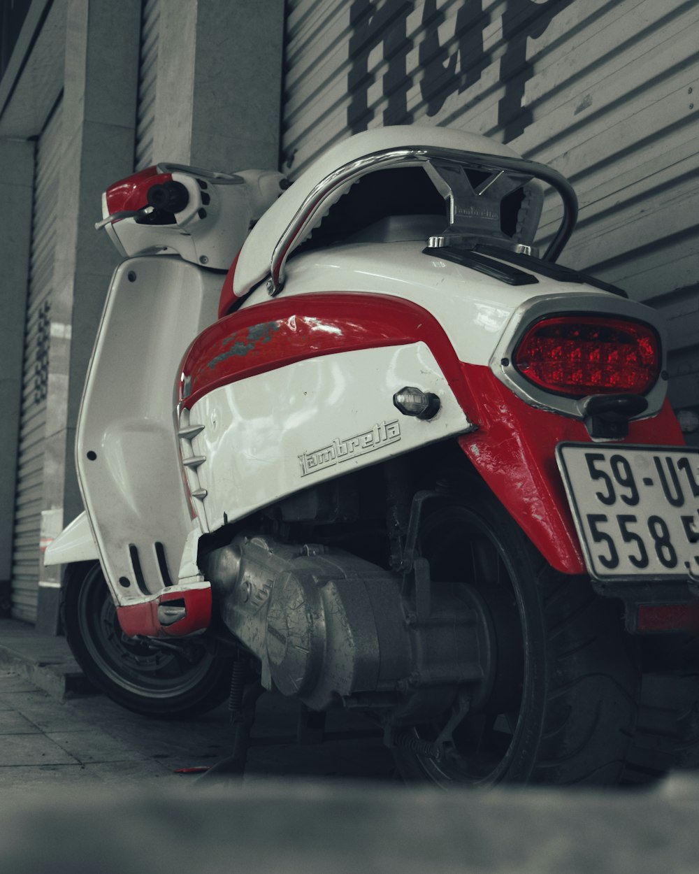 a red and white scooter parked next to a building